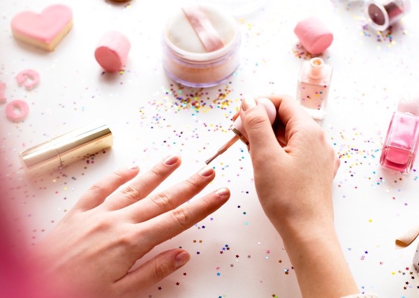 Woman with pink hair doing nail polish
